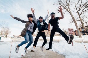 3 young people jumping and looking happy