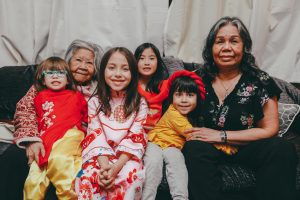 A family of 3 generations looking to camera