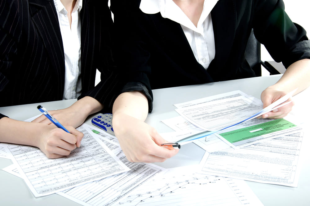 Two people sat at a table looking over documents